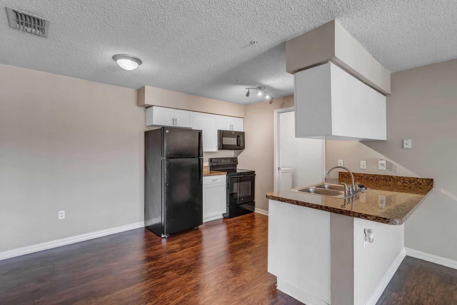 Luxury apartment kitchen with stainless steel appliances, granite countertops, and lots of storage space